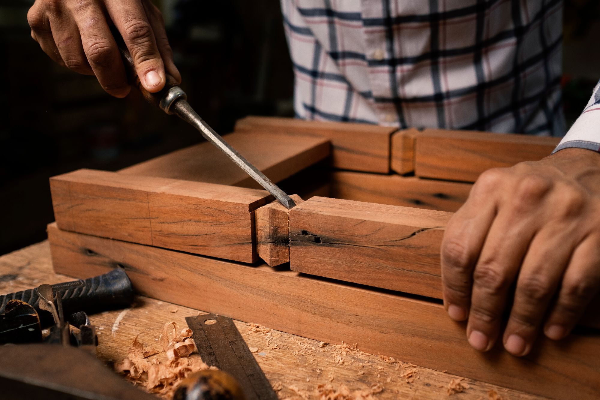 Craftsman hand-checking a sprayed cabinet door before curing